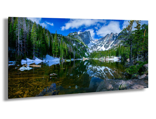 a lake surrounded by trees and snow covered mountains